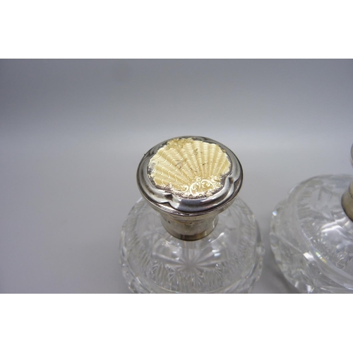 855 - A pair of silver and enamel cut glass scent bottles, Birmingham 1934, enamel a/f on one