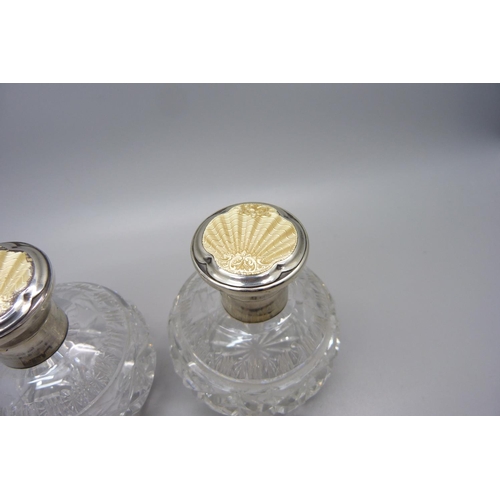 855 - A pair of silver and enamel cut glass scent bottles, Birmingham 1934, enamel a/f on one