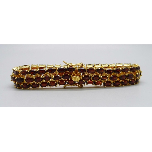 866 - A silver gilt, three row garnet bracelet