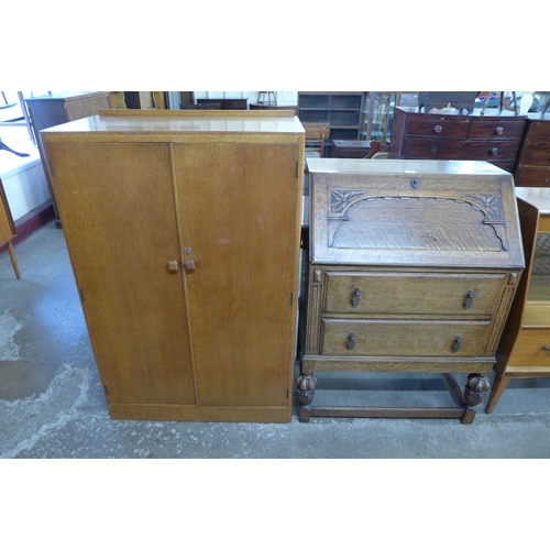 105 - A Jacobean Revival carved oak bureau and an Art Deco oak tallboy