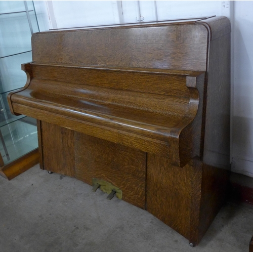 116 - An Art Deco Bentley oak overstrung upright piano, with faux ivory plastic keys, retailed by Ascotts,... 