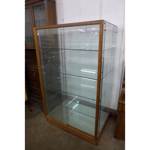 117 - A glazed oak shop display cabinet, 152cms h, 93cms , 63cms d