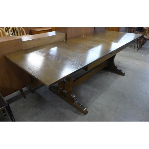 125 - An oak extending refectory table, with carved castle emblem to stretcher