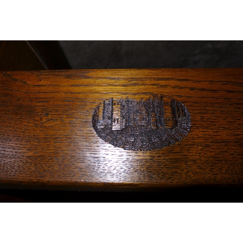 125 - An oak extending refectory table, with carved castle emblem to stretcher