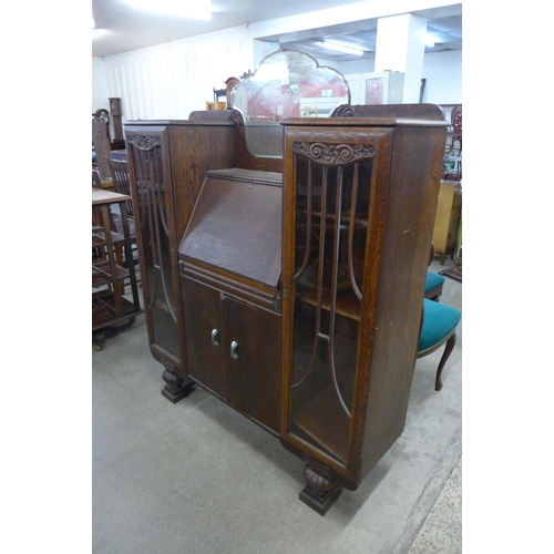 126 - An early 20th Century carved oak side by side bureau bookcase