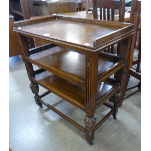 149 - A Jacobean Revival carved oak three tier trolley