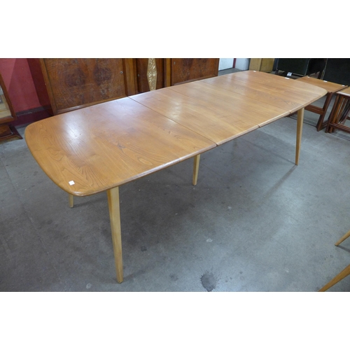 16 - An Ercol Blonde elm and beech Grand Windsor extending dining table and eight Ercol Blonde Quaker mod... 