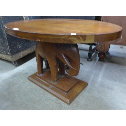 163 - An African carved mahogany elephant based oval coffee table