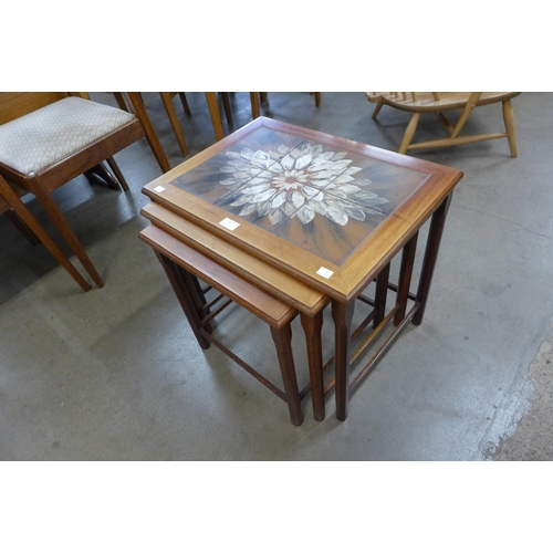 24 - A tiled top teak nest of tables