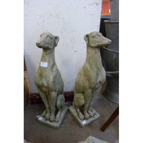 255 - A pair of concrete garden figures of seated greyhound figures