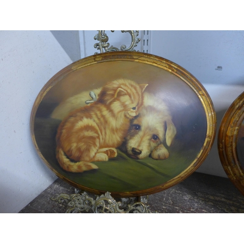 277 - A pair of oval oleographs depicting dogs, with Italian style brass table top easels