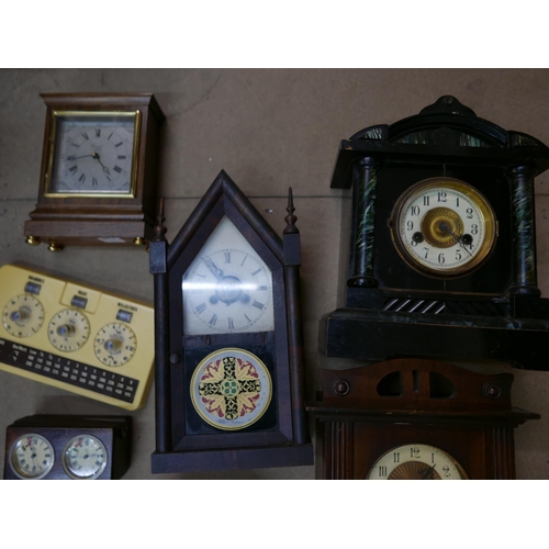 324 - Five mantel clocks, a vintage Metricock weight converter, another timepiece and a cast metal wine ra... 