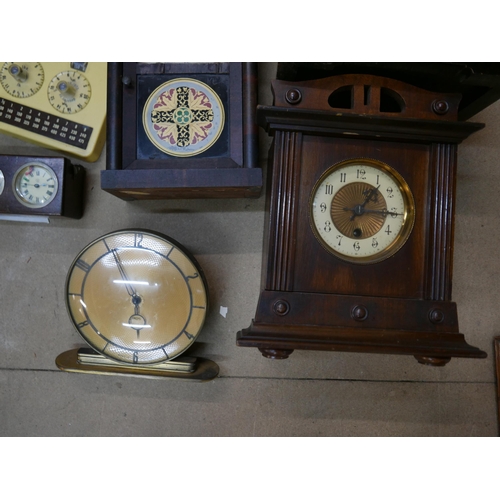 324 - Five mantel clocks, a vintage Metricock weight converter, another timepiece and a cast metal wine ra... 