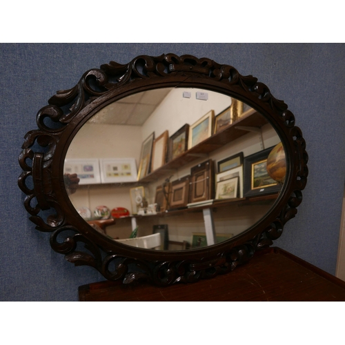 327 - An Edward VII carved oak oval framed mirror