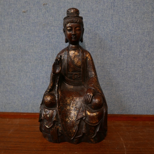 358 - An oriental faux bronze figure of a seated deity