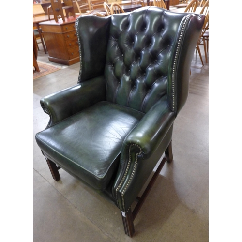 70 - A green leather Chesterfield wingback armchair