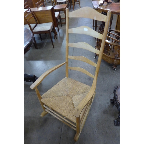 77 - An Arts and Crafts Ernest Gimson style ash and rush seated rocking chair