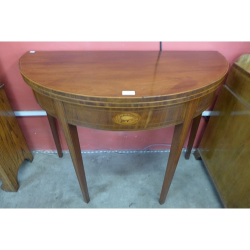 86 - A George III inlaid mahogany demi-lune fold over tea table