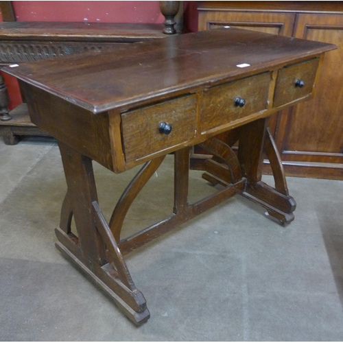 94 - A Victorian Gothic Revival oak three drawer writing table, in the manner of A.W.N. Pugin