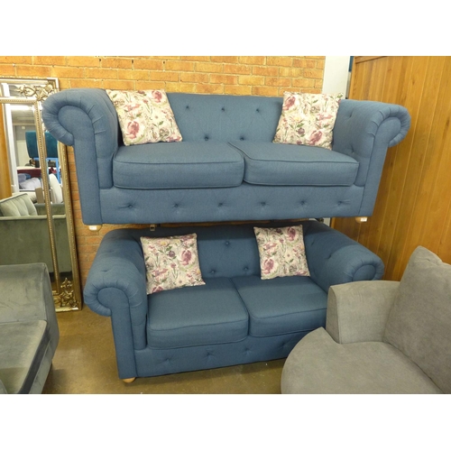 1526 - A pair of blue textured weave upholstered Chesterfield sofas with patterned scatter cushions