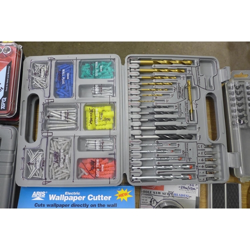 2051 - A box of assorted tool sets, electric wallpaper cutter, hole saw blades, socket sets and more