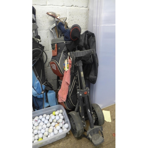 2228 - 3 golf bags with quantity of woods, irons and golf trolley with a tub of Approx. 150 golf balls