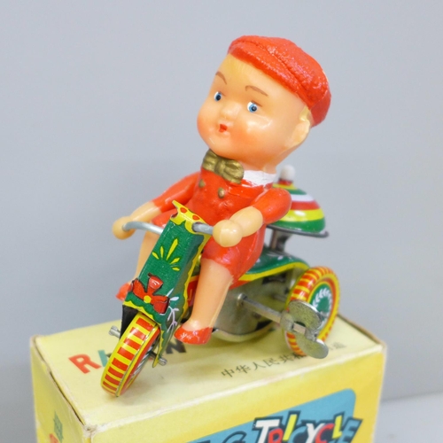 644 - A small Chinese tin plate toy tricycle, boxed