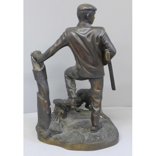 692 - A cast metal sculpture of a gamekeeper and his dog