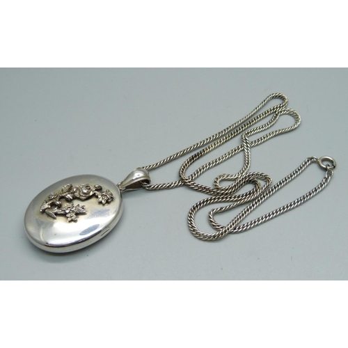 939 - A white metal locket on chain, locket 34mm wide, chain 66cm