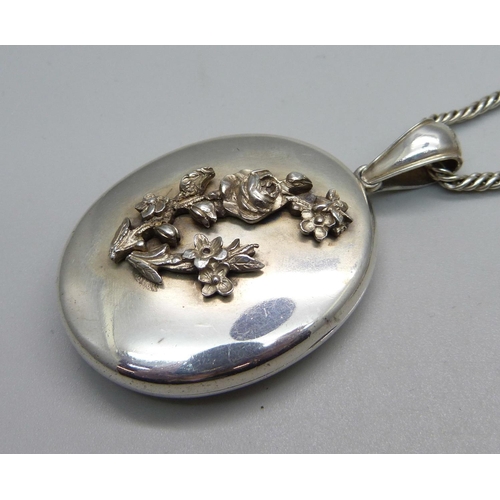 939 - A white metal locket on chain, locket 34mm wide, chain 66cm