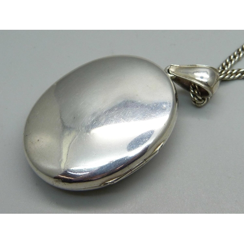 939 - A white metal locket on chain, locket 34mm wide, chain 66cm