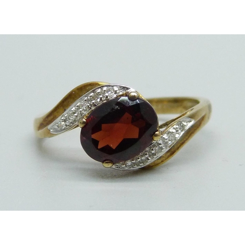 946 - A 9ct gold, garnet and diamond crossover ring, 2.8g, S