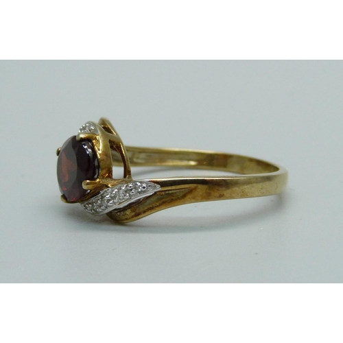 946 - A 9ct gold, garnet and diamond crossover ring, 2.8g, S