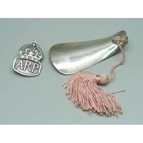 947 - A silver ARP badge and a silver child's shoe horn