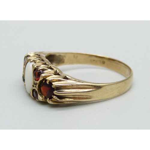 959 - A 9ct gold ring set with an opal and six garnets, 3.4g, R, (very small chip to the opal)