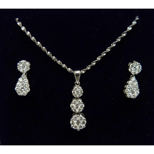 973 - A 14ct white gold and diamond triple cluster drop pendant and chain and matching earrings (silver sc... 