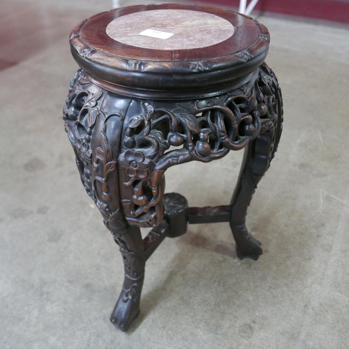 100 - A Chinese carved padouk wood and marble topped jardiniere stand