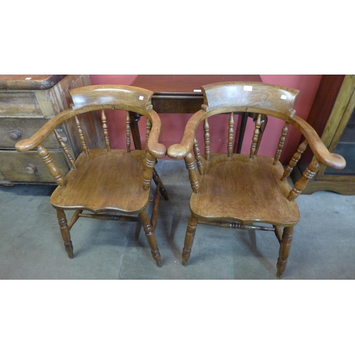 114 - A pair of Victorian style elm and beech smokers bow chairs