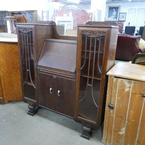 181 - An early 20th Century carved oak side by side bureau bookcase