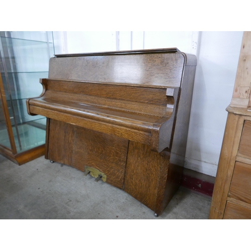 193 - An Art Deco Bentley oak overstrung upright piano, with faux ivory plastic keys, retailed by Ascotts,... 