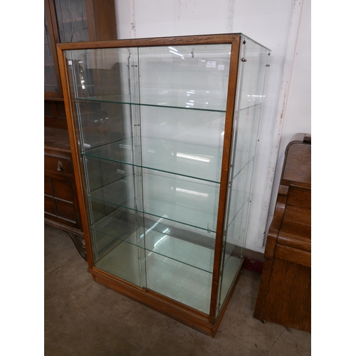 194 - A glazed oak shop display cabinet, 152cms h, 93cms , 63cms d