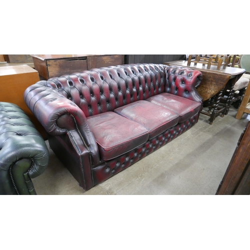 203 - An oxblood red leather Chesterfield settee