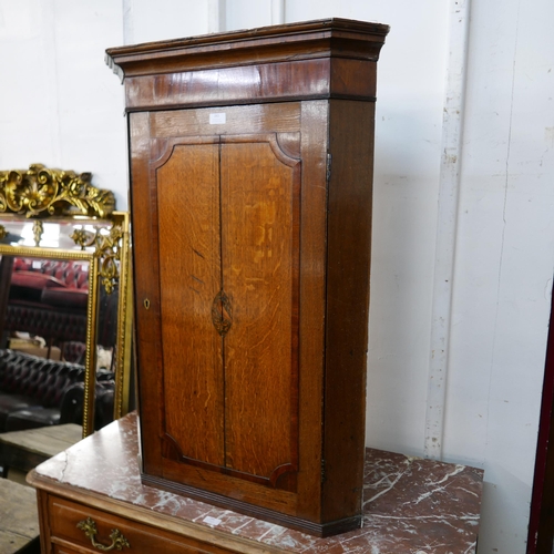 243 - A George III inlaid oak wall hanging corner cupboard