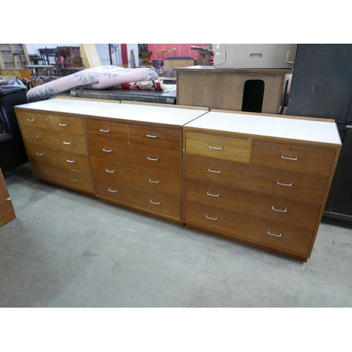 253 - Five mid 20th Century teak and Formica topped M.O.D. chest of drawers