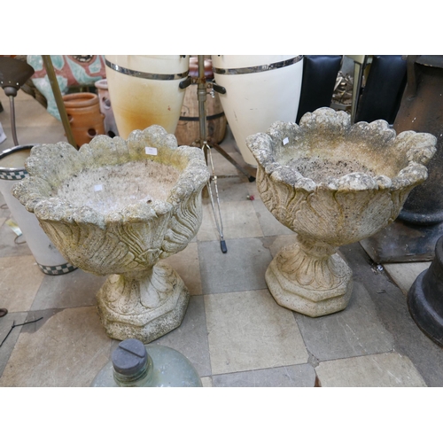 306 - A pair of concrete campana shaped garden urns on stands