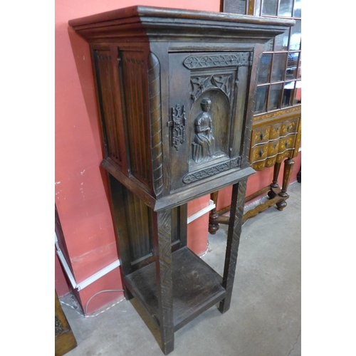 111 - An Elizabethan Revival carved oak cabinet on stand