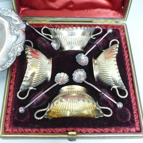 1072 - A cased set of four late Victorian plated salts, a chamber stick and two dishes on a stand/base **PL... 