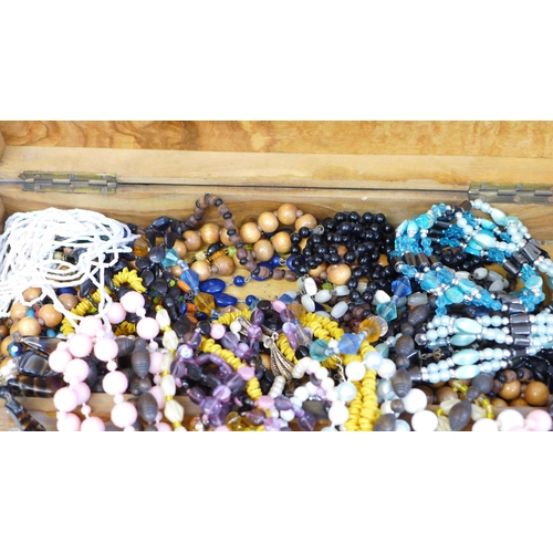 665 - A collection of bead necklaces in two wooden boxes