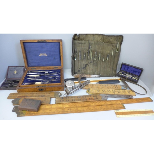 696 - A box containing old rulers and drawing instruments