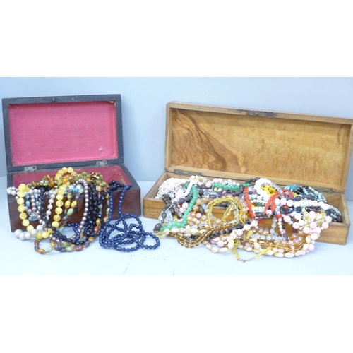 665 - A collection of bead necklaces in two wooden boxes